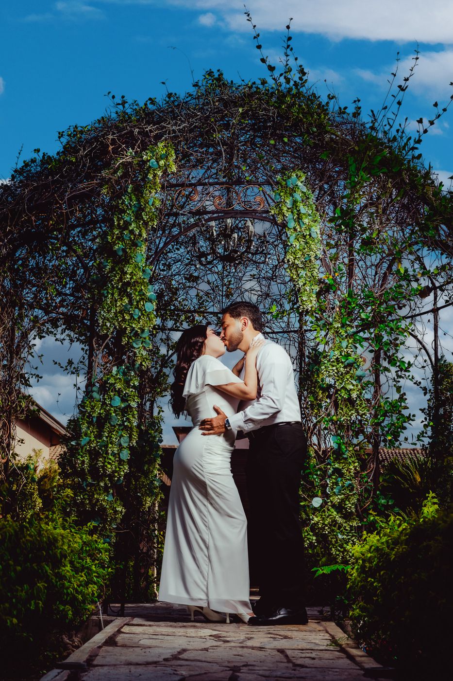 Yeimi y Carlos bajo un arco de jardín